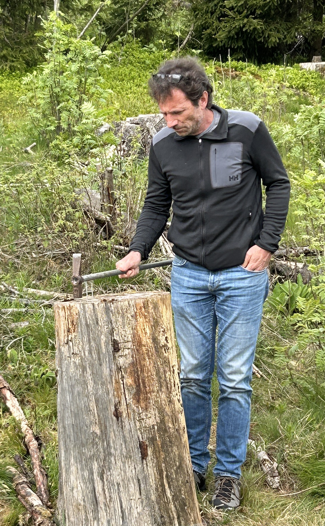 Fachberater Steffen Henkel treibt einen Nagel in den Baumstamm beim freundschaftlichen Wettbewerb während des Väterwochenendes 2024